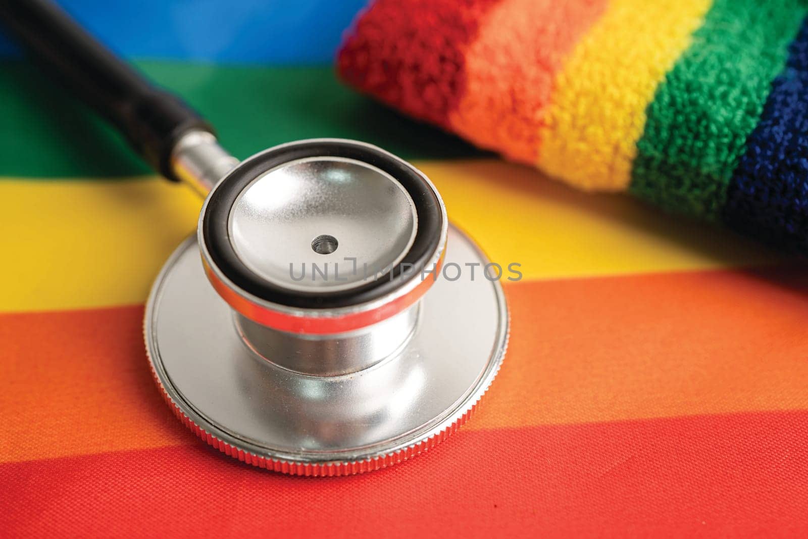 Black stethoscope on rainbow flag background, symbol of LGBT pride month celebrate annual in June social, symbol of gay, lesbian, bisexual, transgender, human rights and peace.