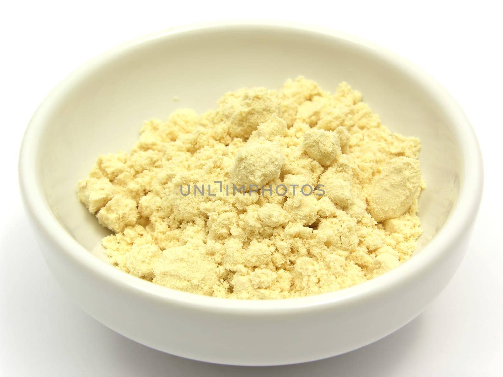 Soy flour in a small white bowl on a white background