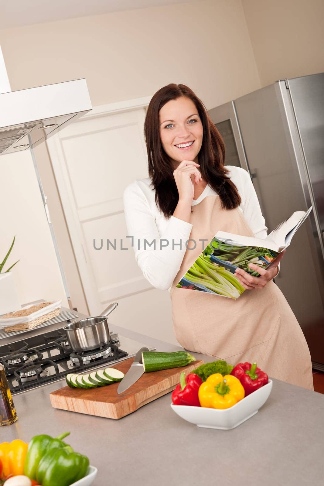 Young smiling woman with groceries in the kitchen