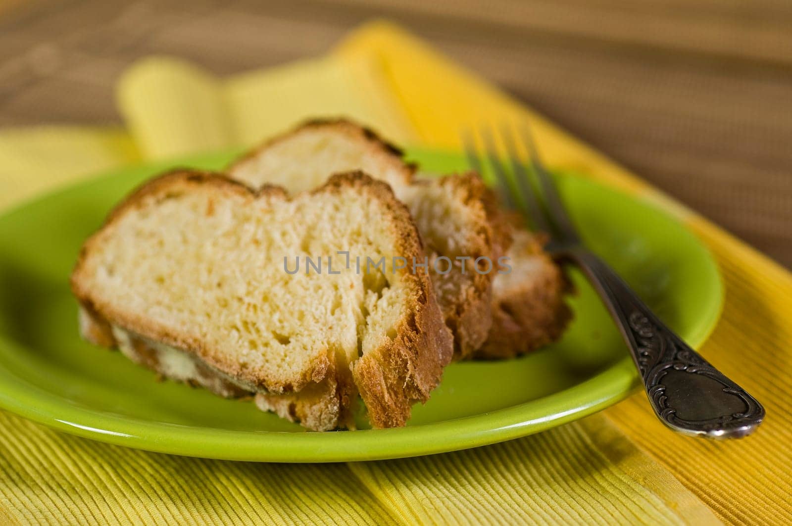 Yeast plait in slices on green plate