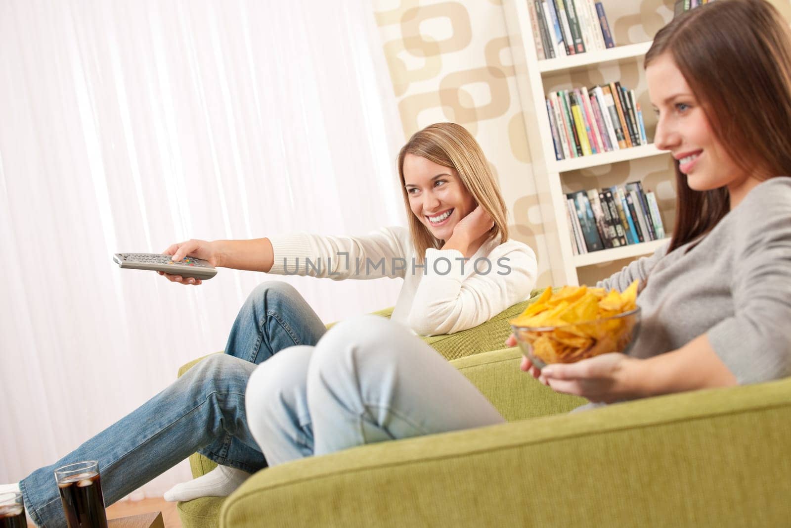 Two female teenager watching television