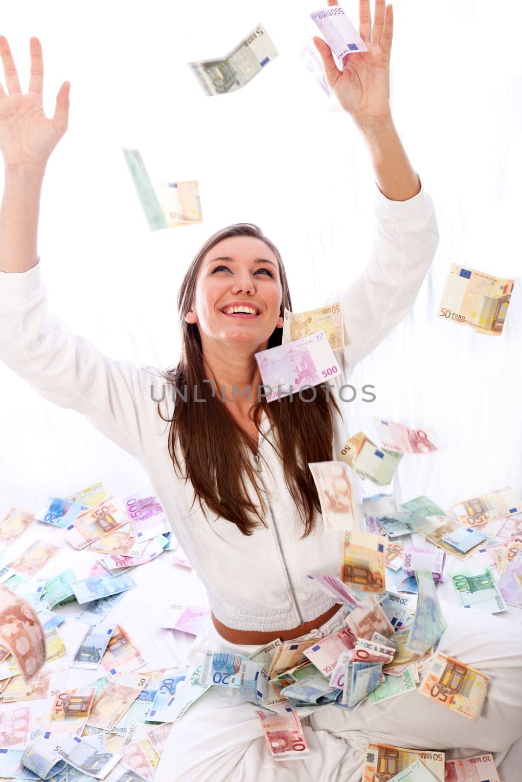 Young woman sitting happily in the rain of money