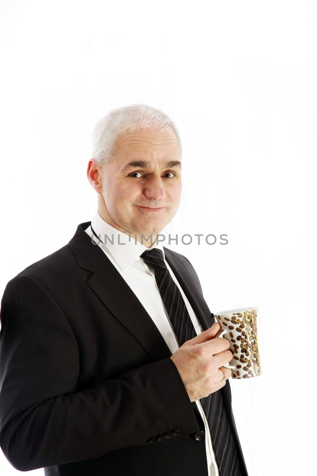 A friendly, elderly gentleman in a suit drinking coffee