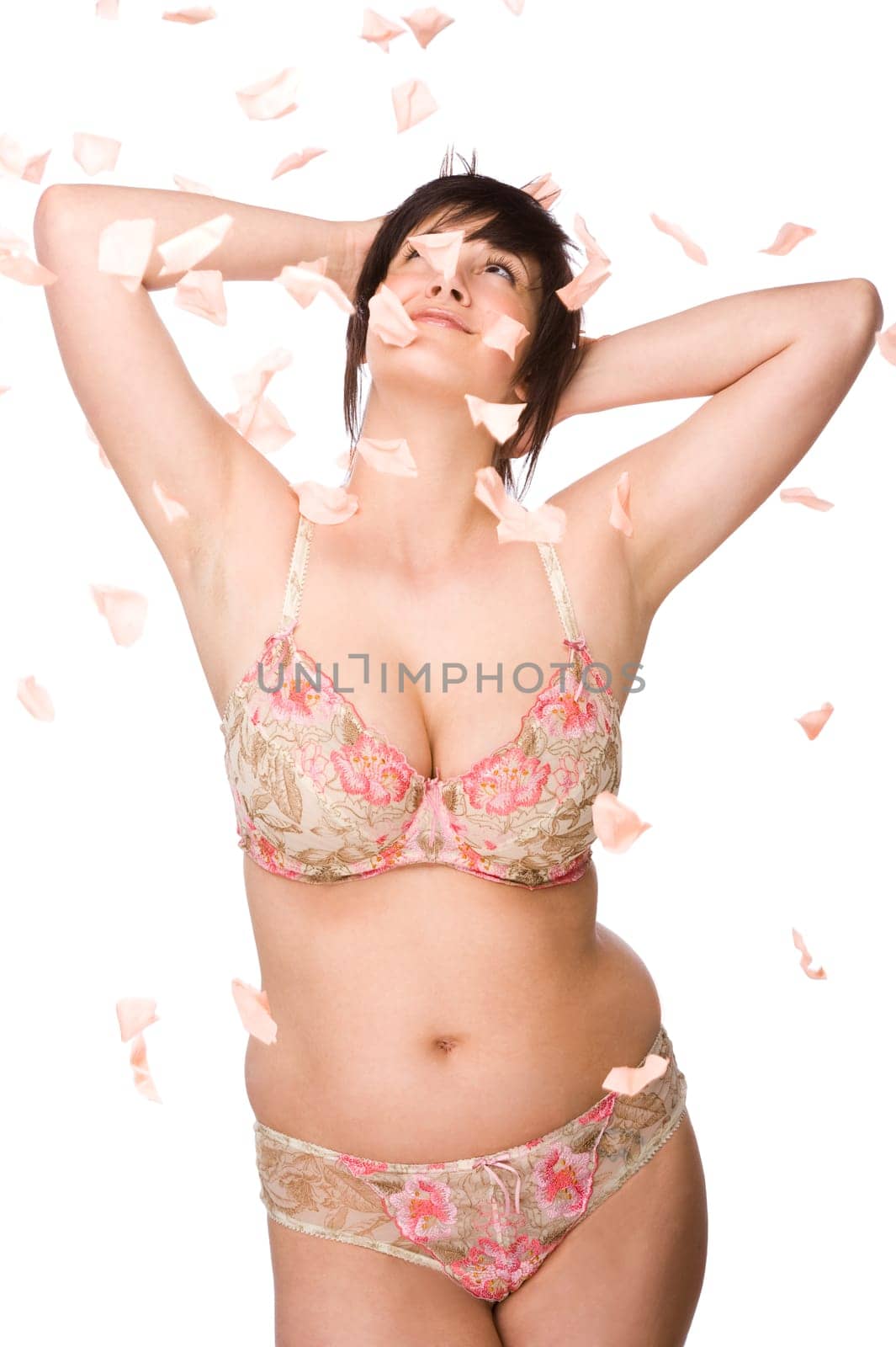 Young woman with flying rose petals