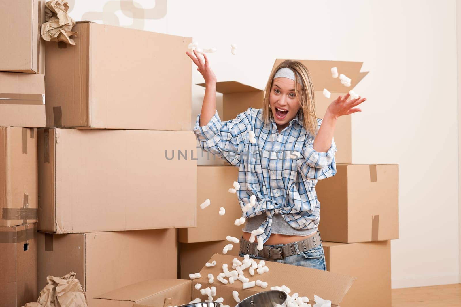 Moving house Woman unpacking box with kitchen dishes