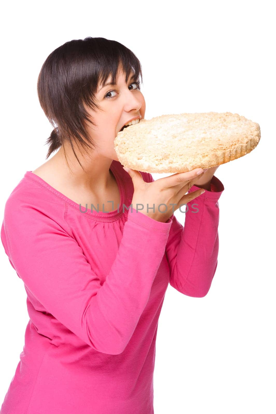Young woman bites into a cake