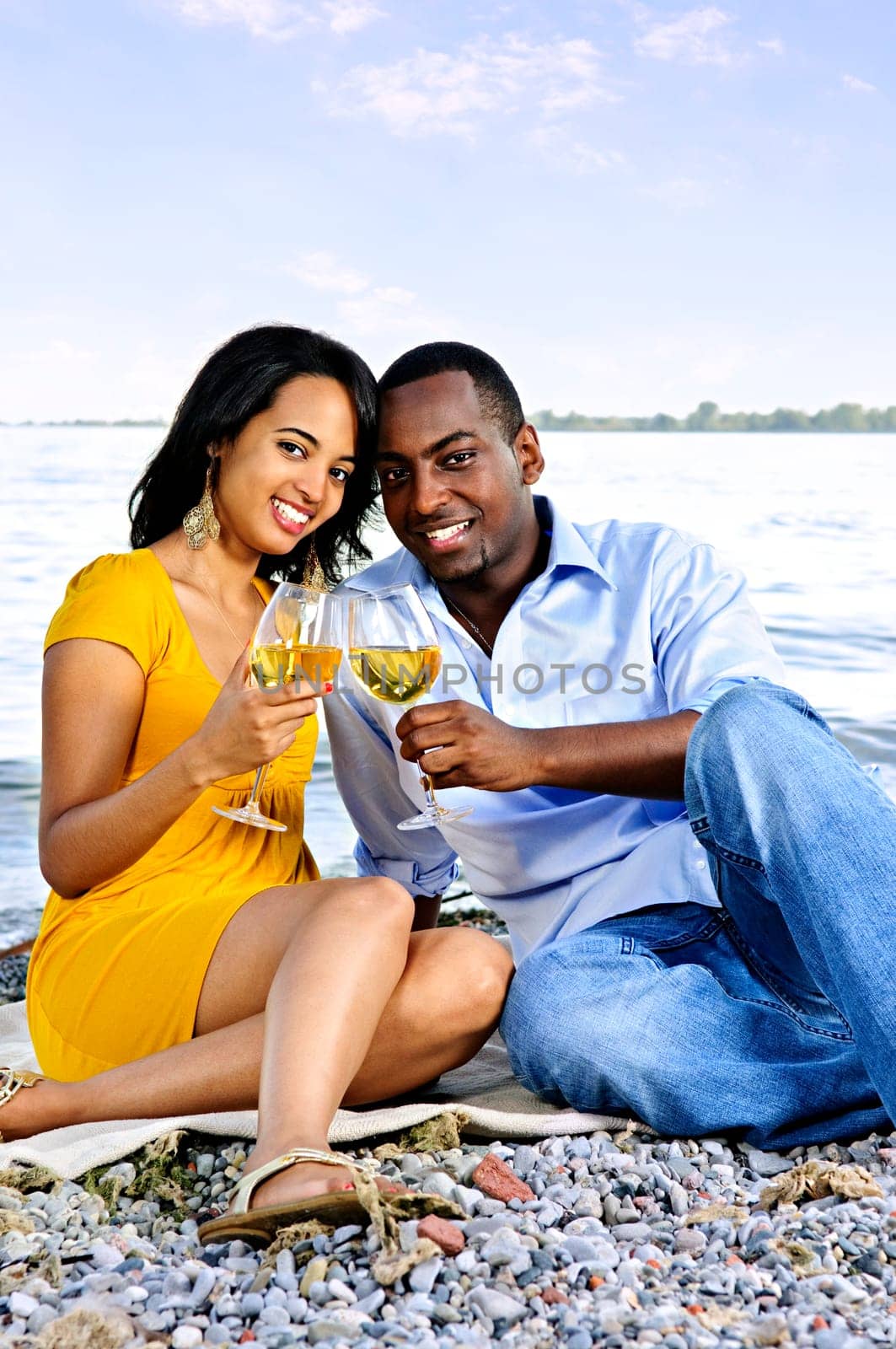 Happy couple having wine on beach