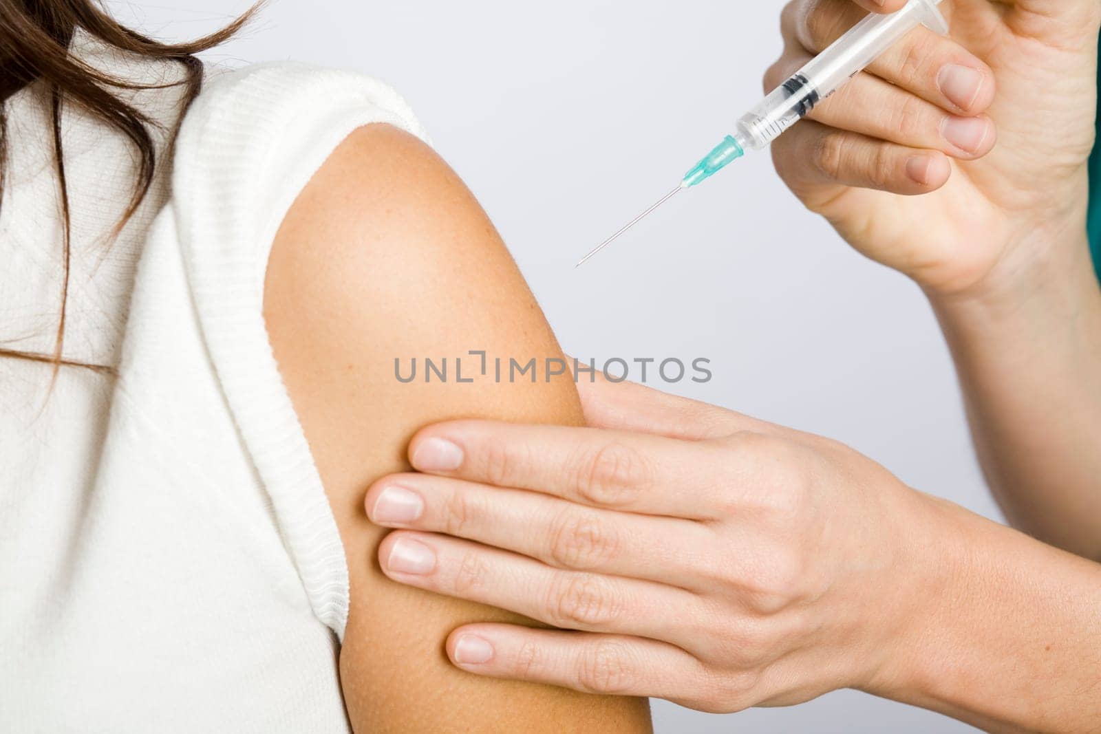 Young nurse vaccinating female patient