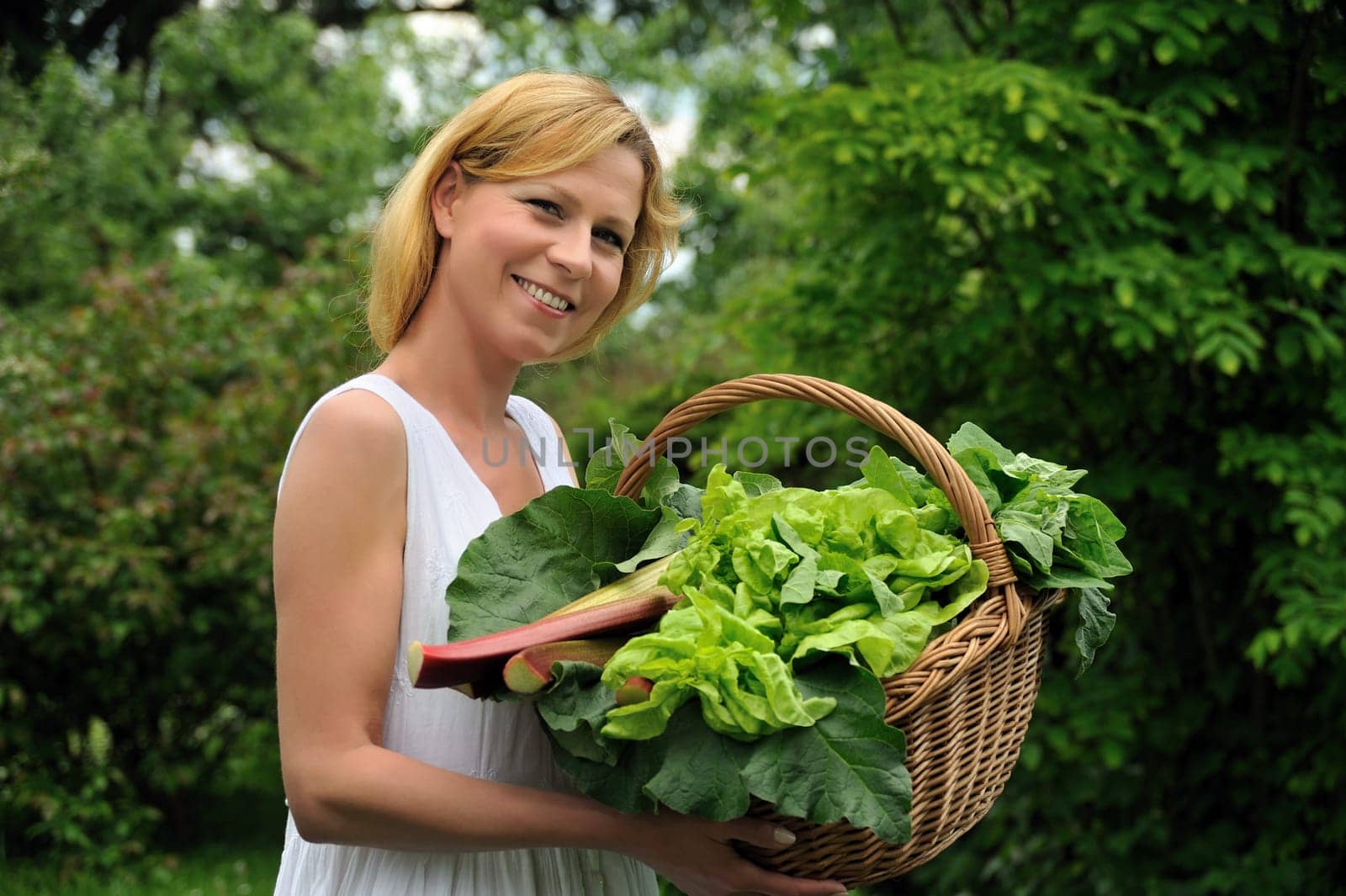 Young woman holding basket with vegetable