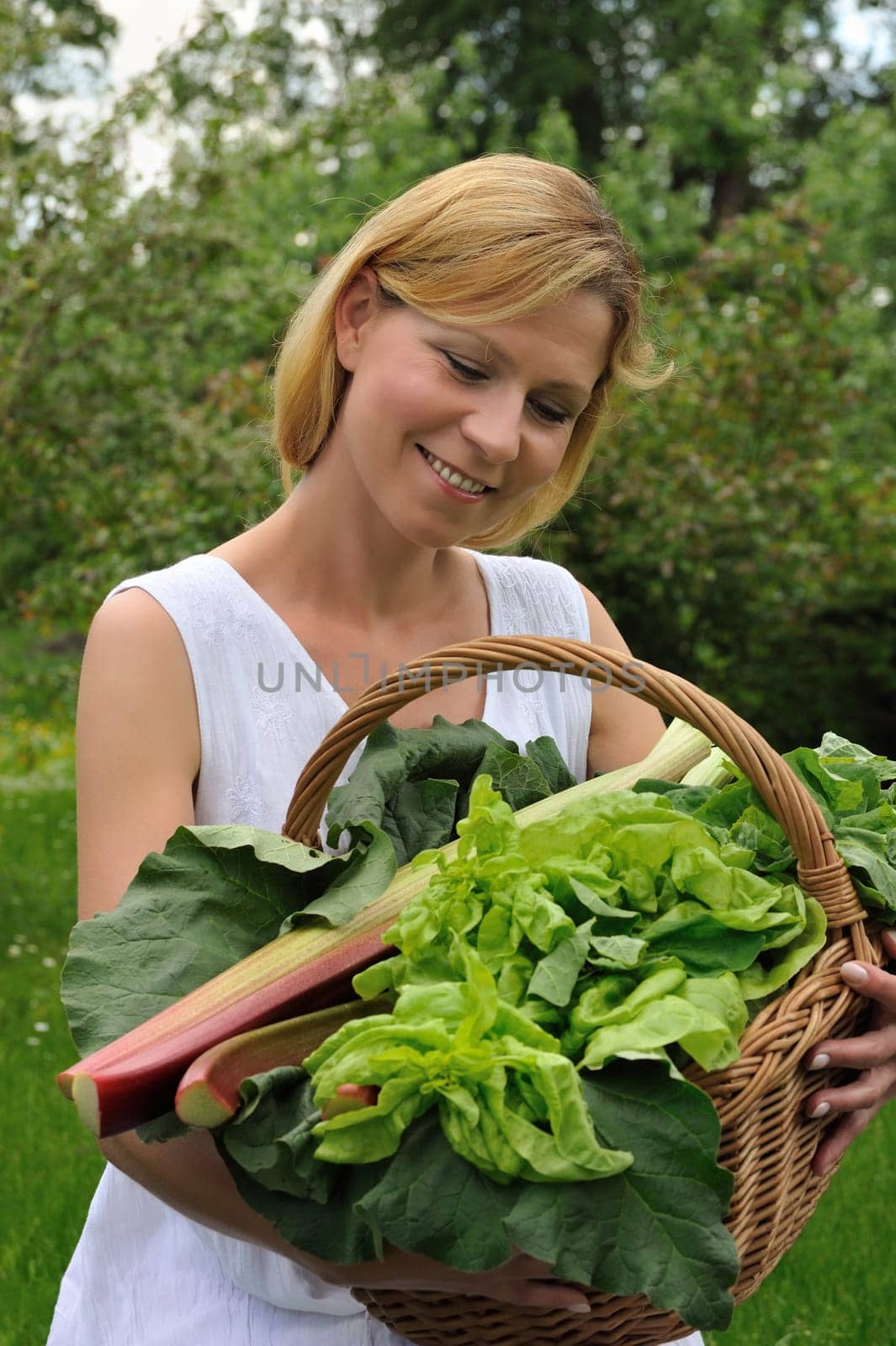 Young woman holding basket with vegetable