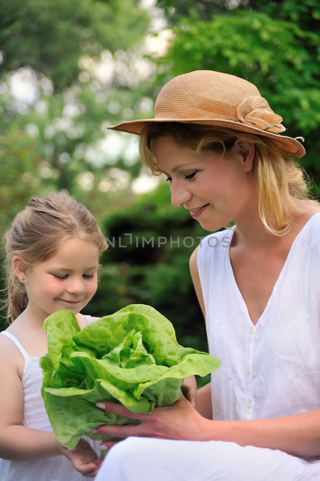 Young mother and daughter with lettuce