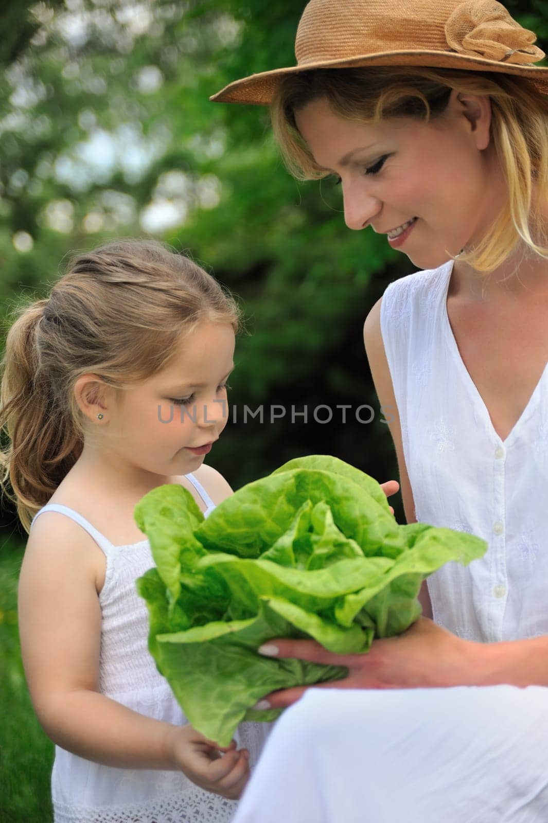 Young mother and daughter with lettuce