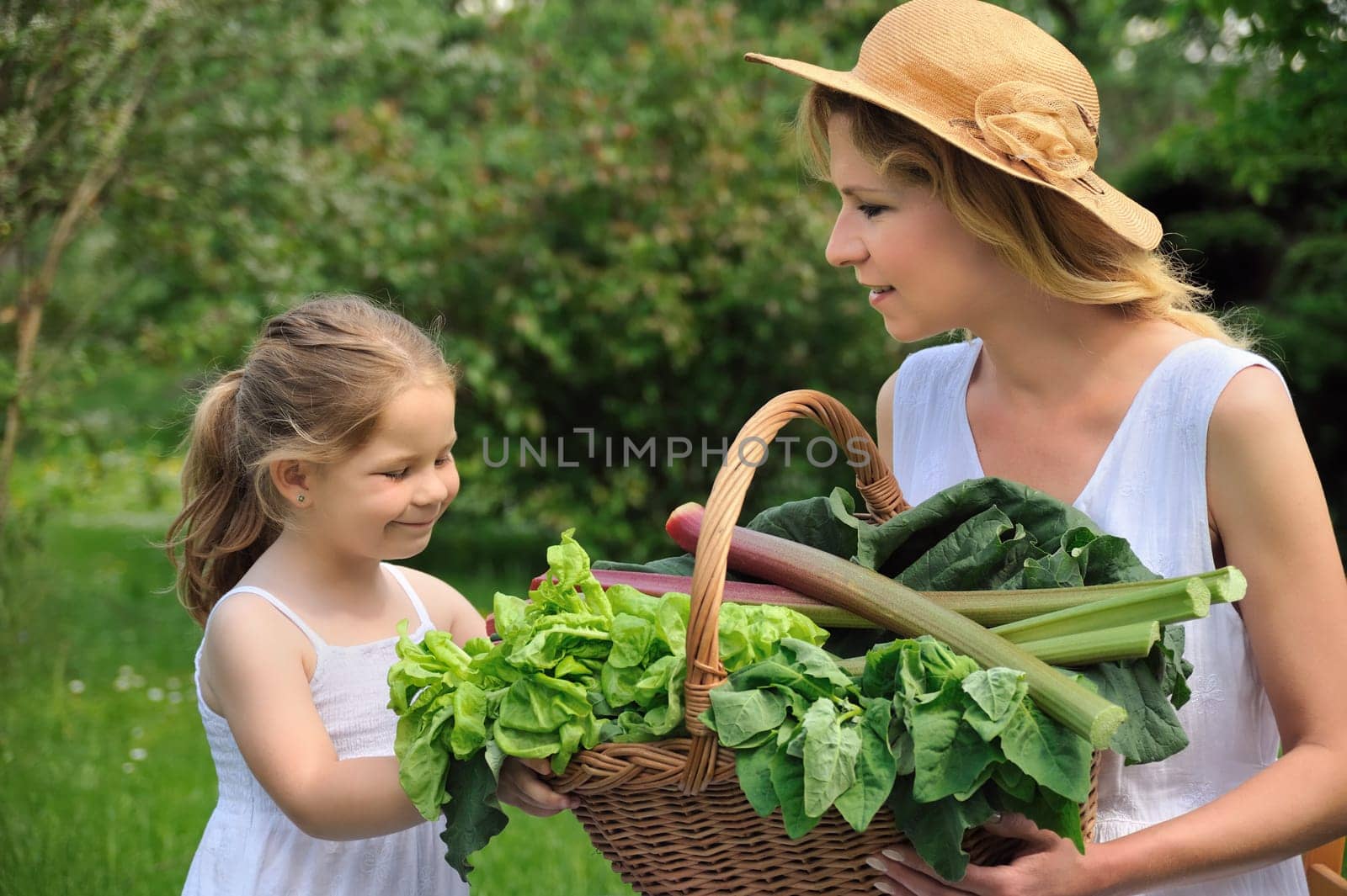Young woman and daughter with fresh vegetable