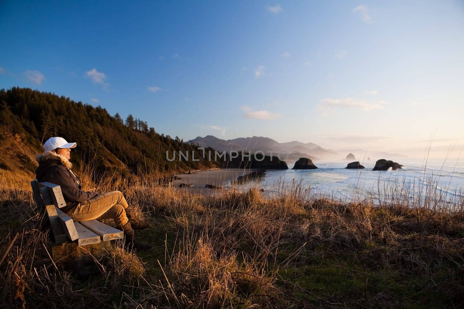 woman on bench overlooking coast