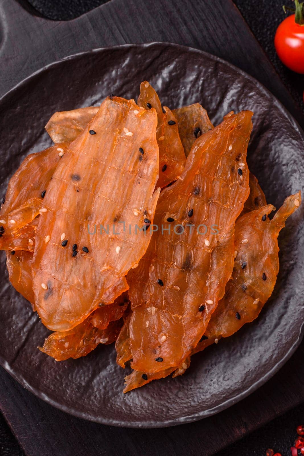 Jerky, dried chicken meat with salt and spices on a dark concrete background