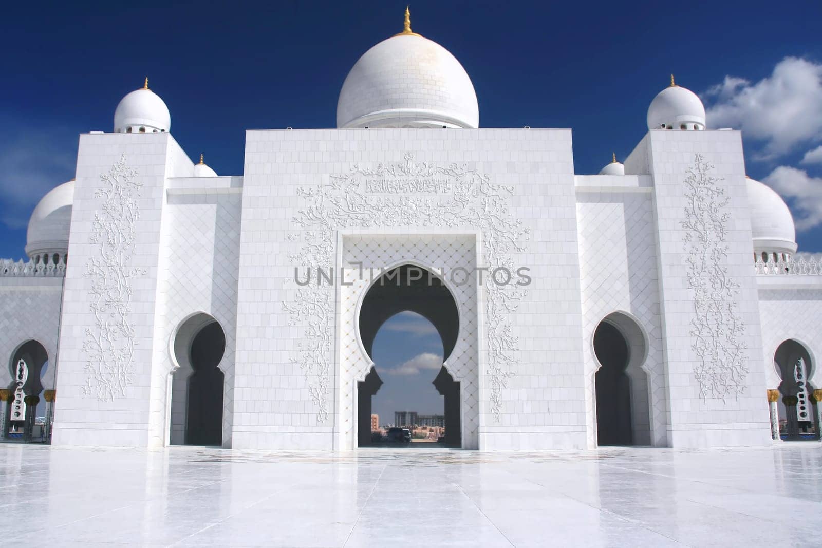 white mosque with cloudy blue sky