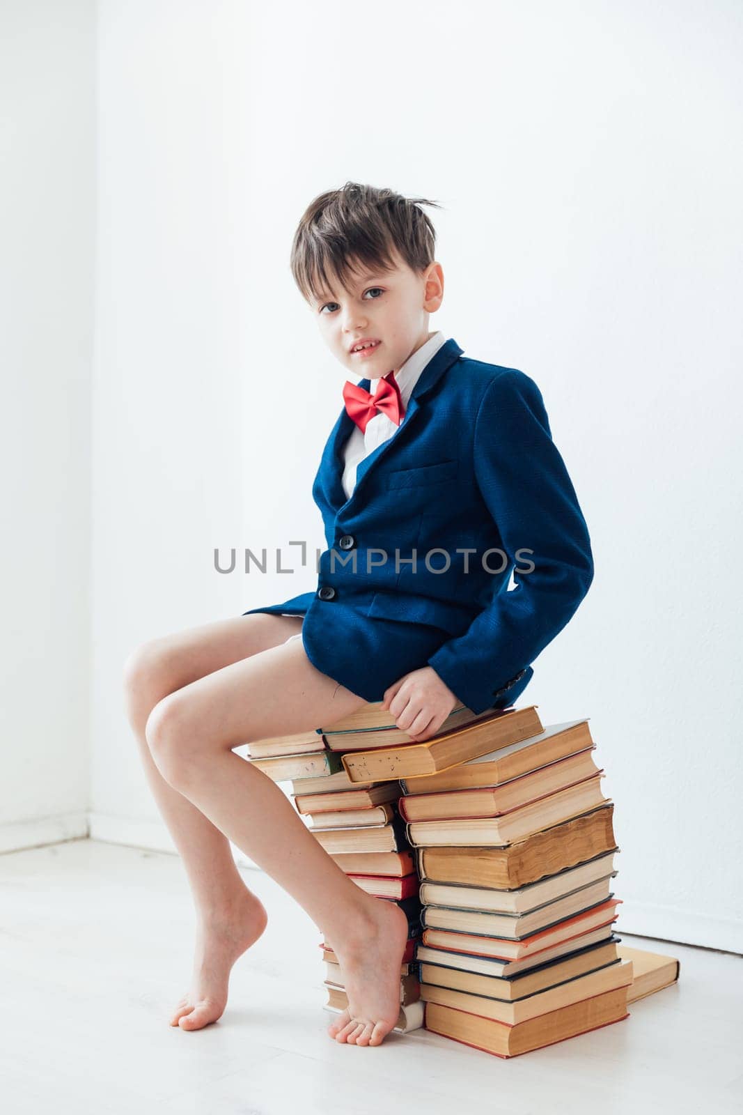 child sitting on books gets knowledge learning reading science by Simakov