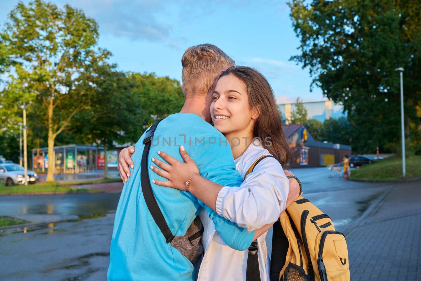 Outdoor teenage friends meeting, hugging on city street by VH-studio