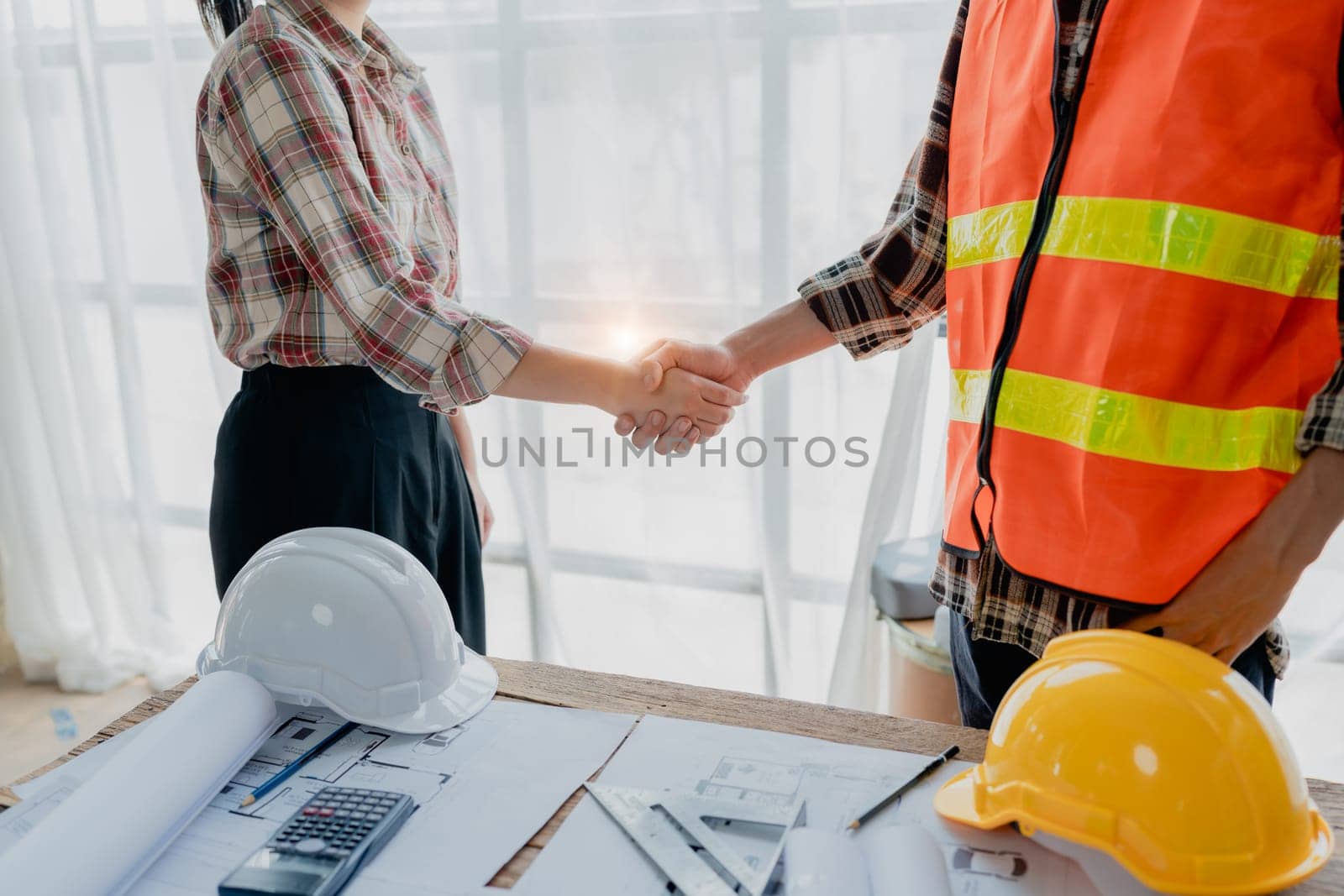Engineers, designers and interior designers are handshake shack hands deal finalizing the design of interiors by discussing selecting materials and colors to design rooms to present to clients