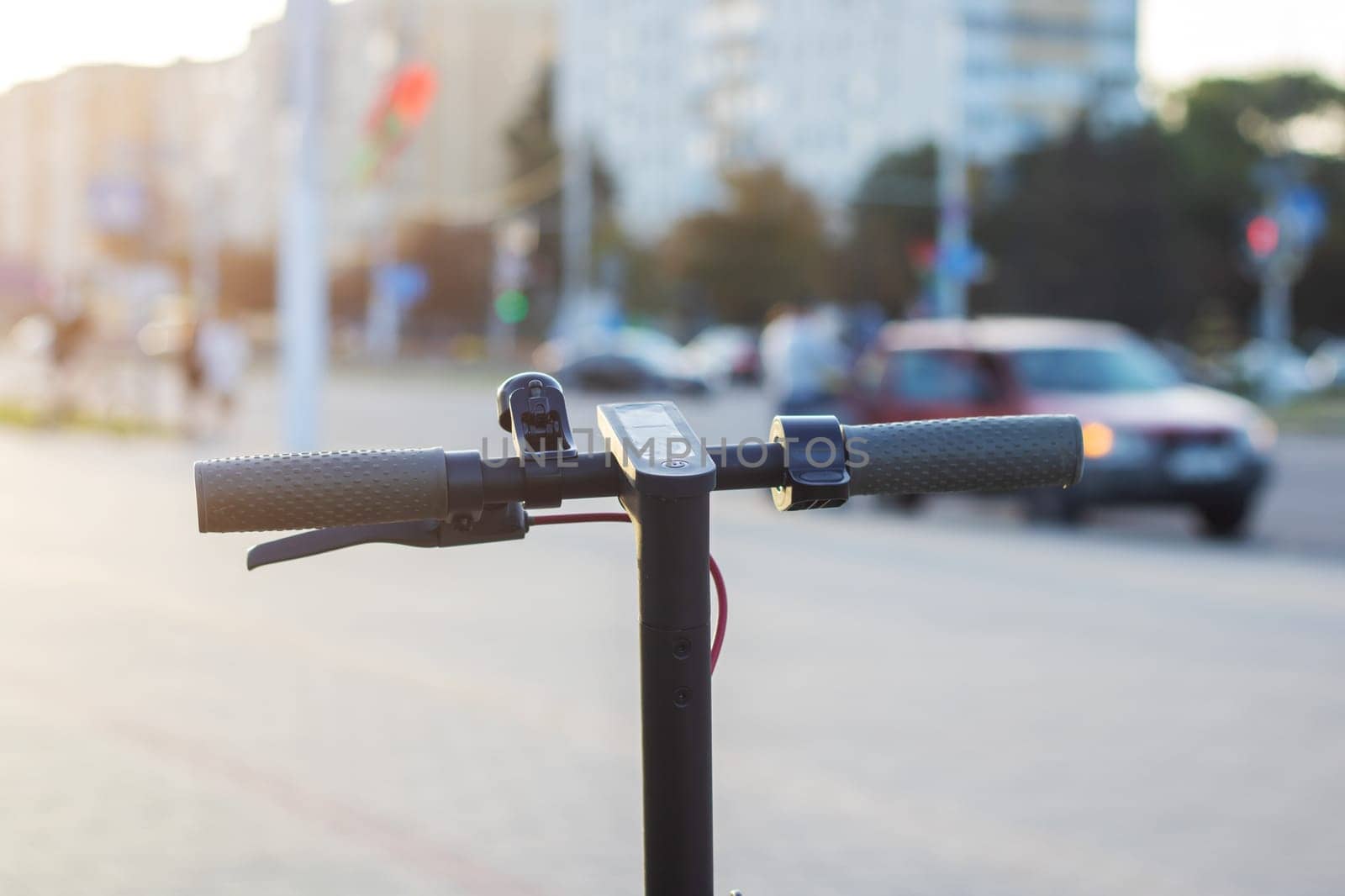 Electric scooter against the background of the city at sunset close up