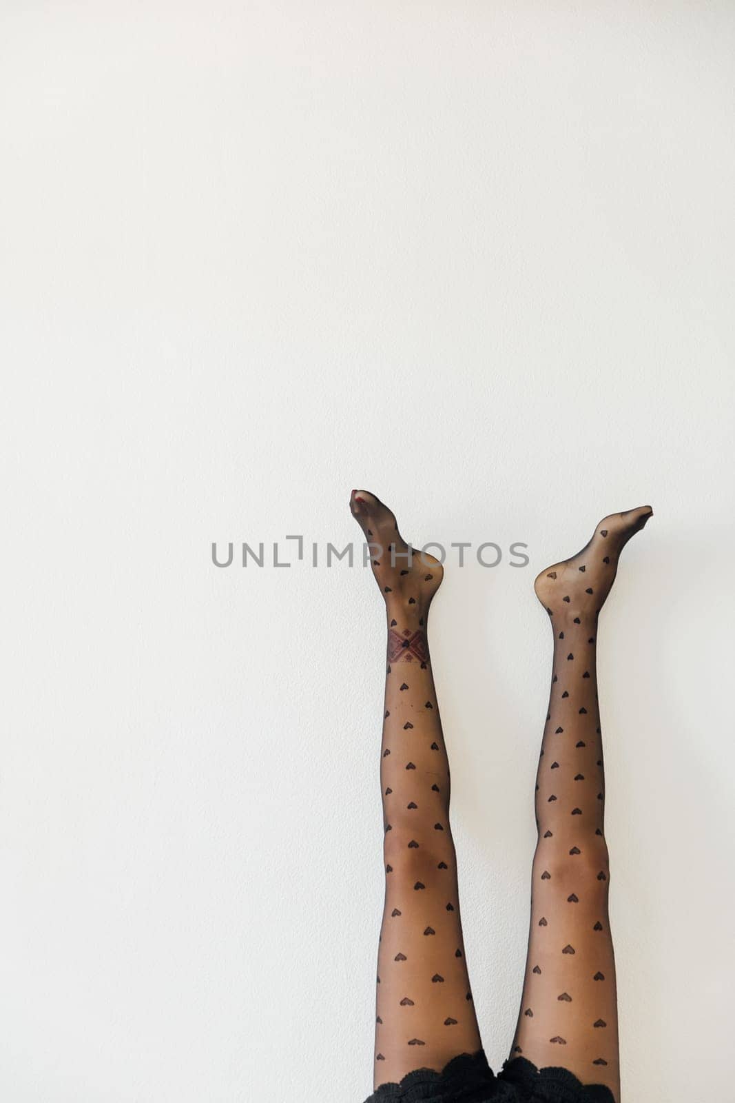 a women's slender legs in black tights on a white background
