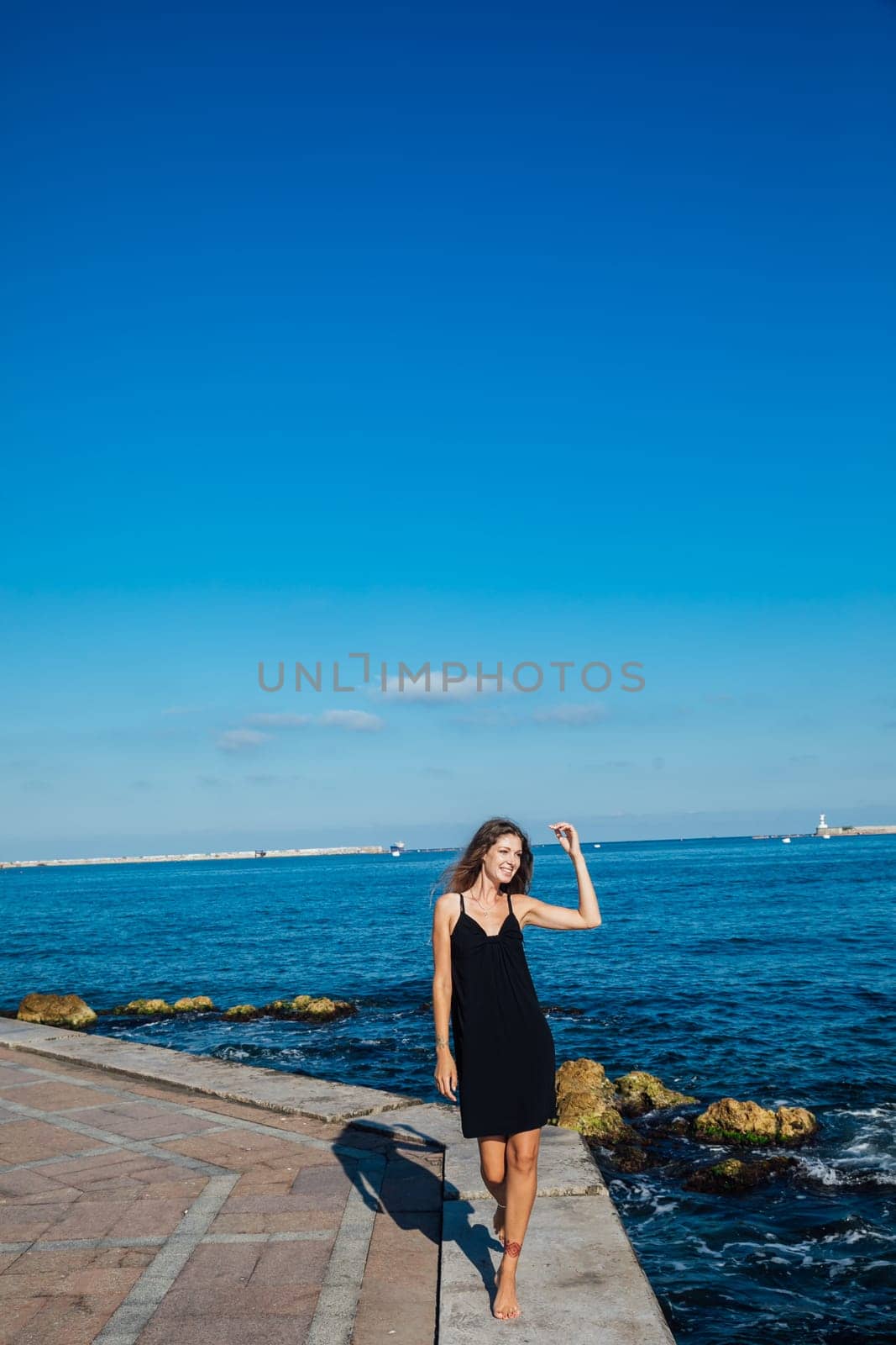 woman walks along a pier near the sea walking the beach