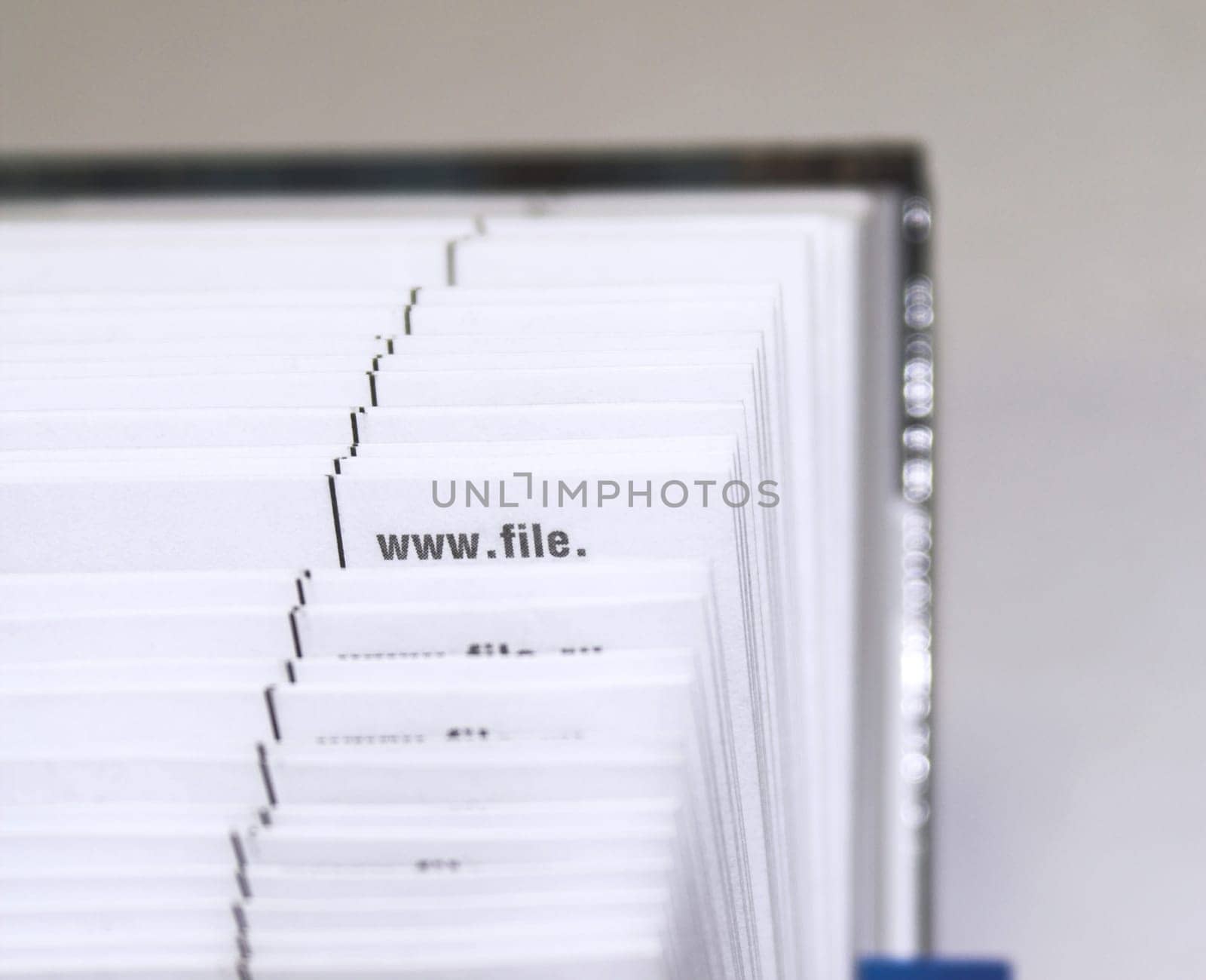 The cutting face of a phone directory with fanned pages.