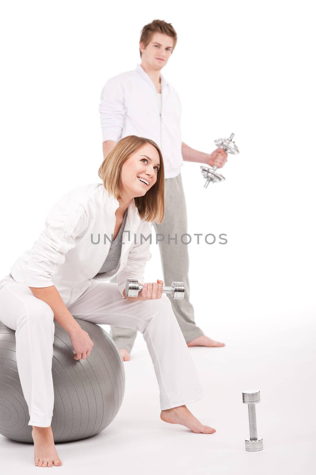 Fitness - Young couple training with weights and ball
