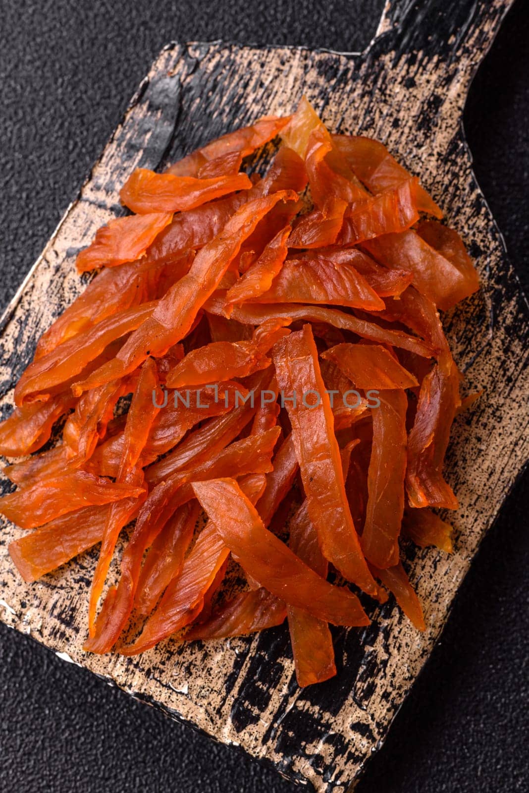 Jerky, dried turkey meat with salt and spices on a dark concrete background