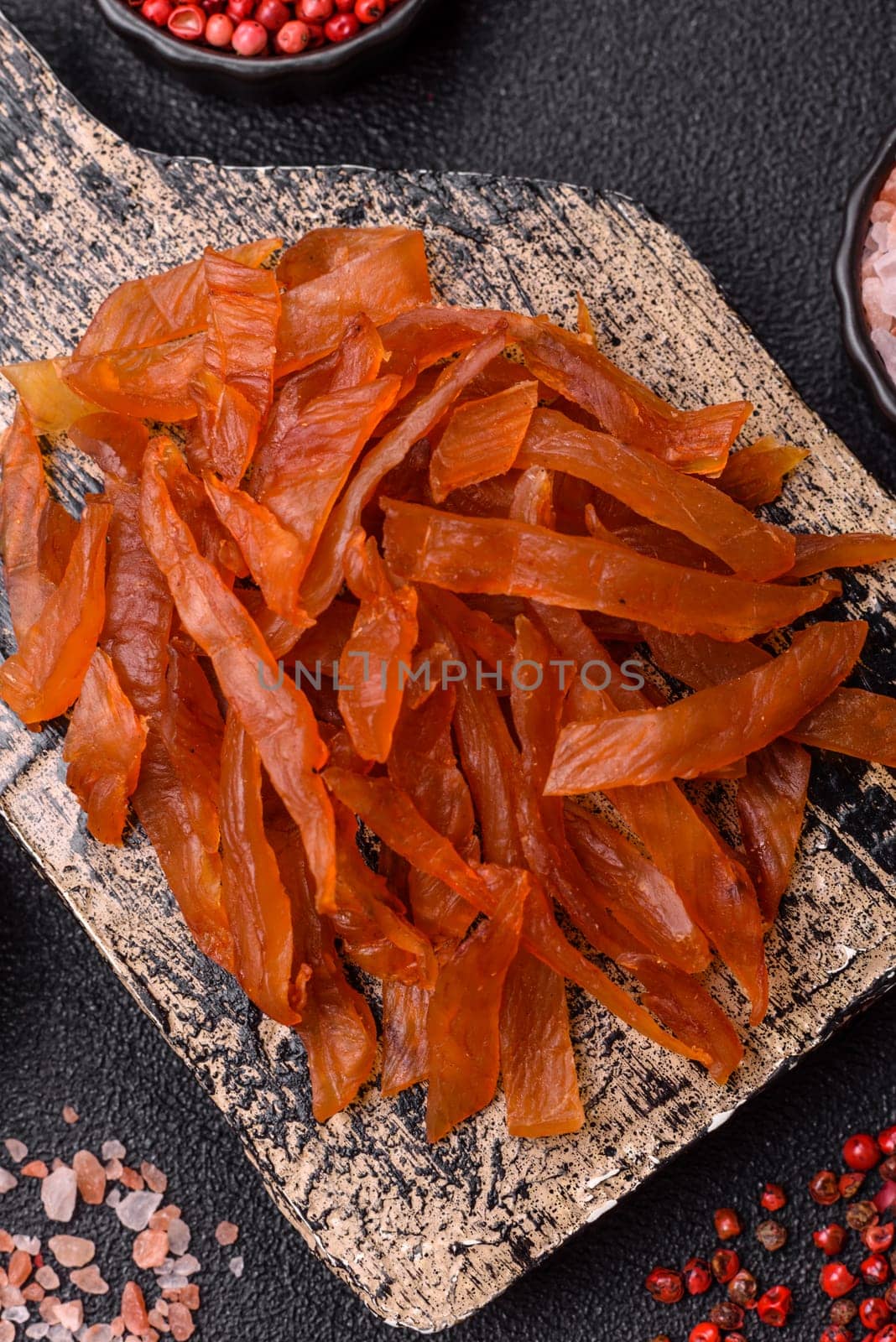 Jerky, dried turkey meat with salt and spices on a dark concrete background