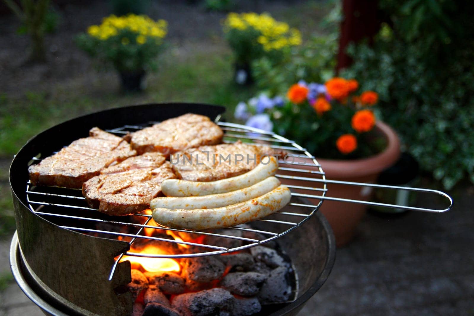 Grill with grilled meat and bratwurst in the garden