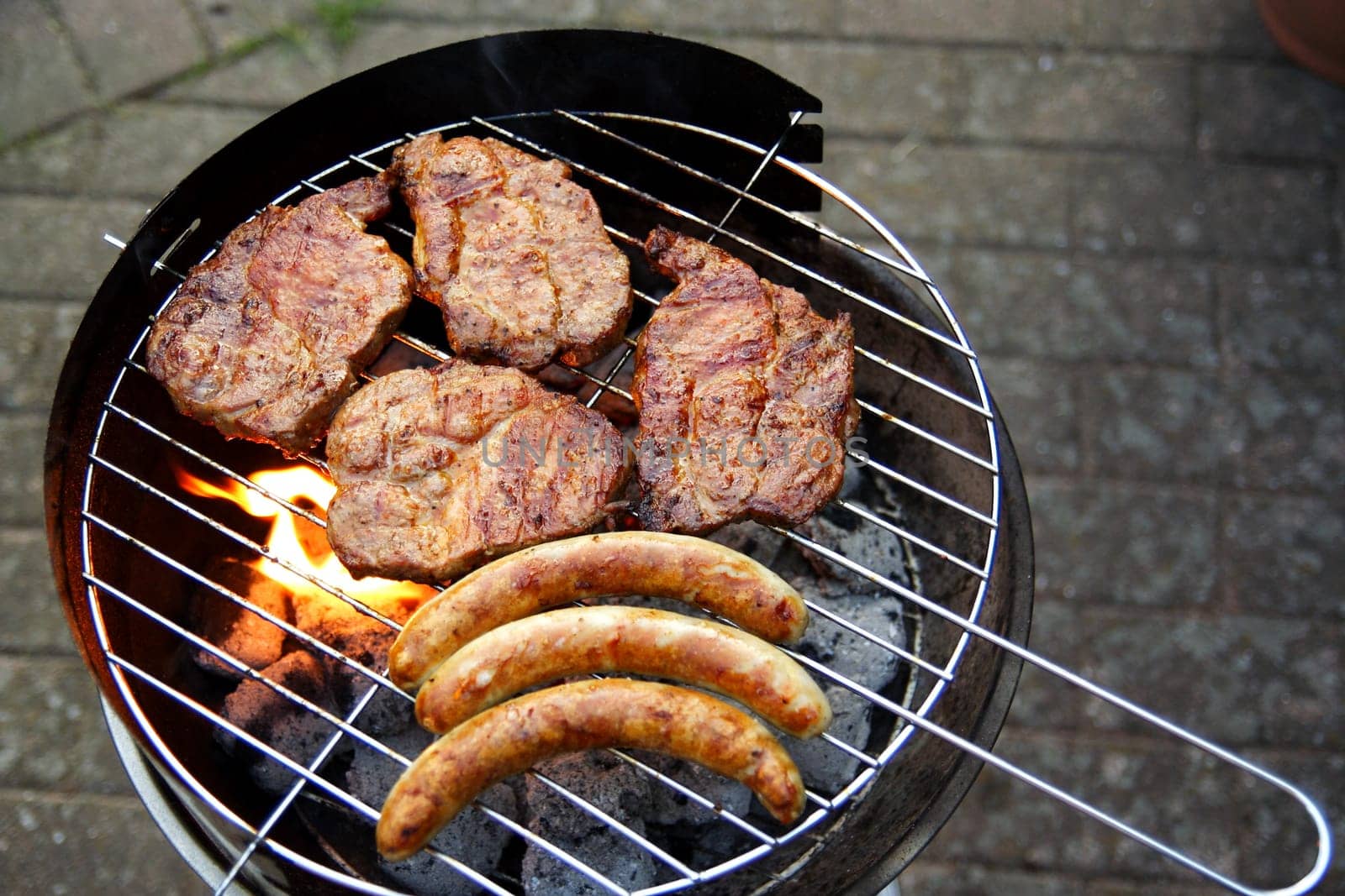 Grill with grilled meat and bratwurst in the garden