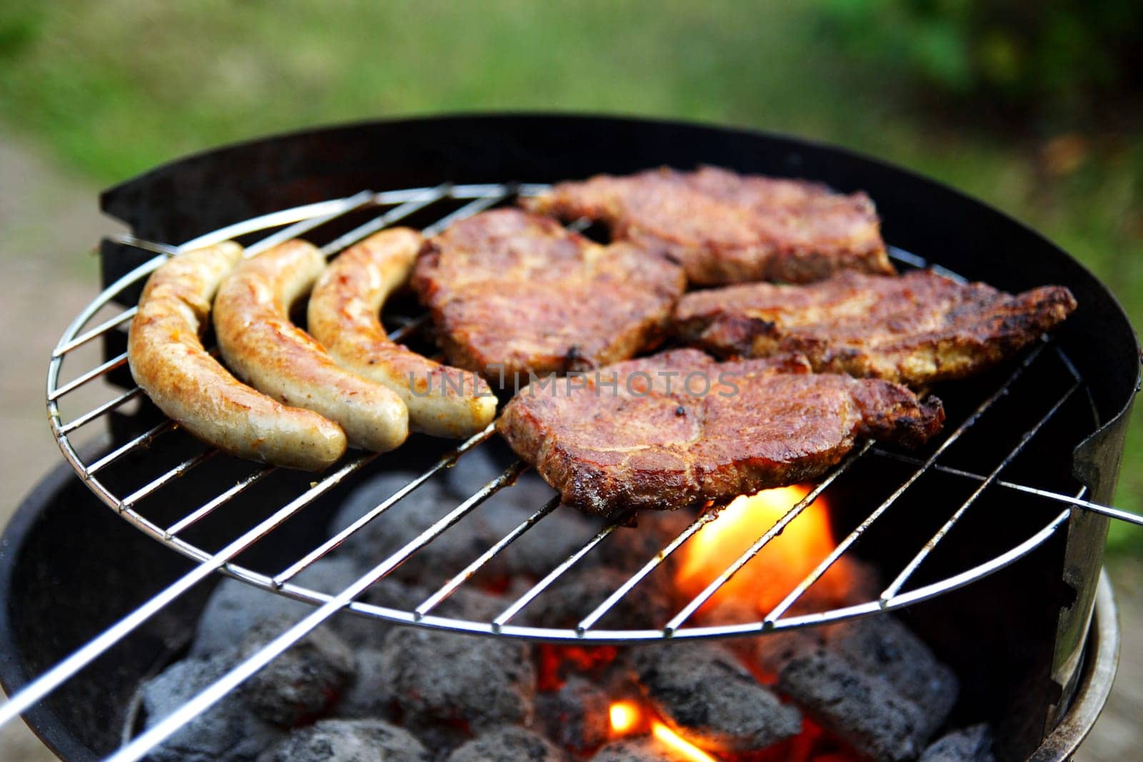 Grill with grilled meat and bratwurst in the garden