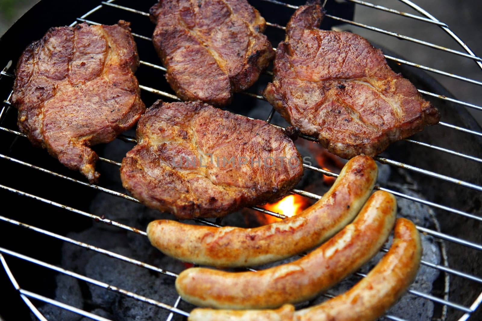 Grill with grilled meat and bratwurst in the garden