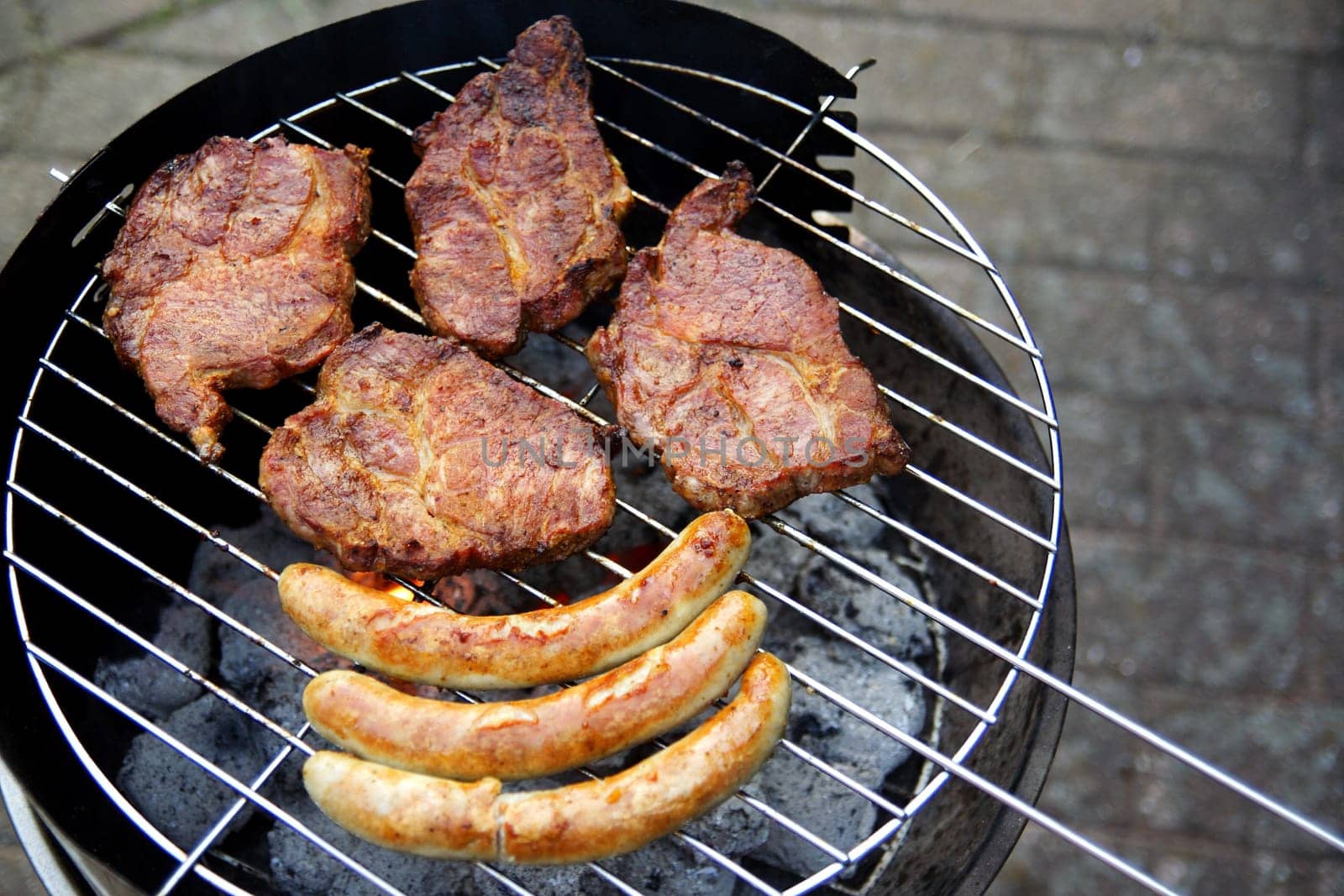 Grill with grilled meat and bratwurst in the garden