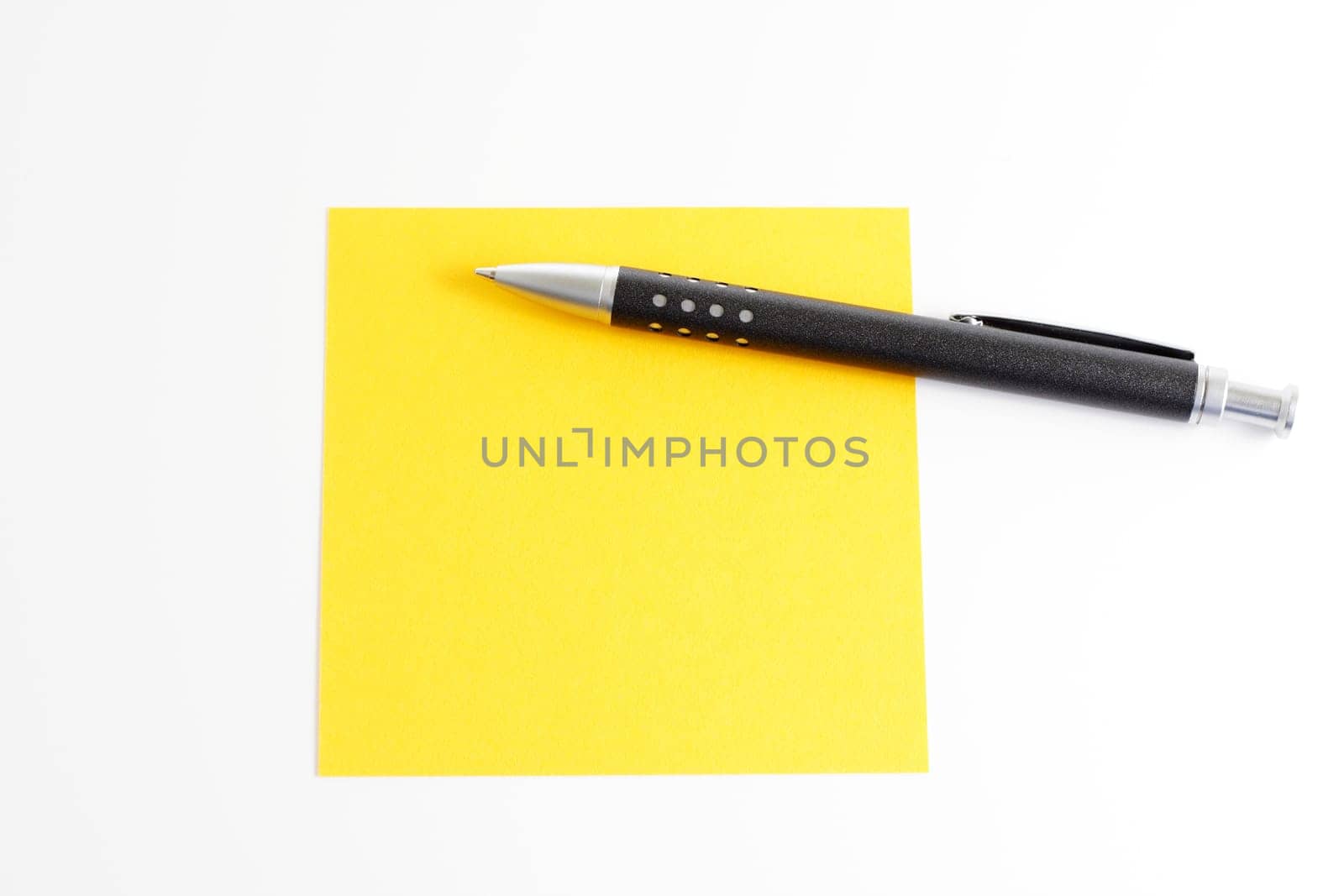 Yellow sticky note with ballpoint pen