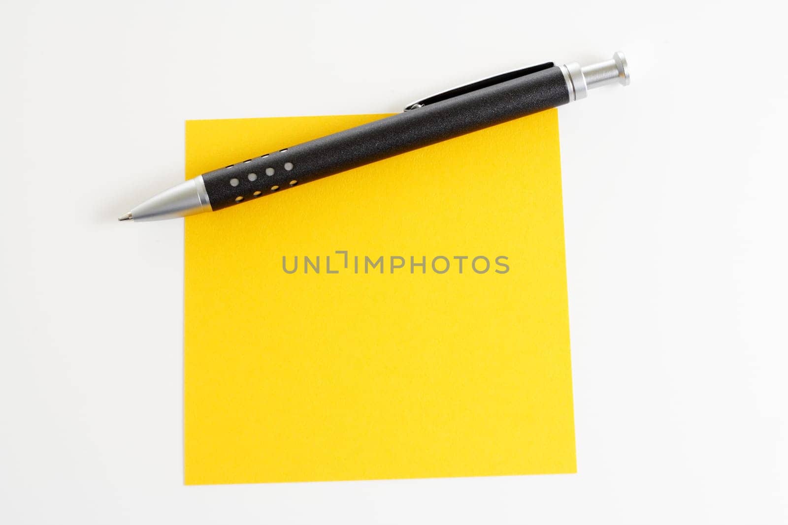 Yellow sticky note with ballpoint pen