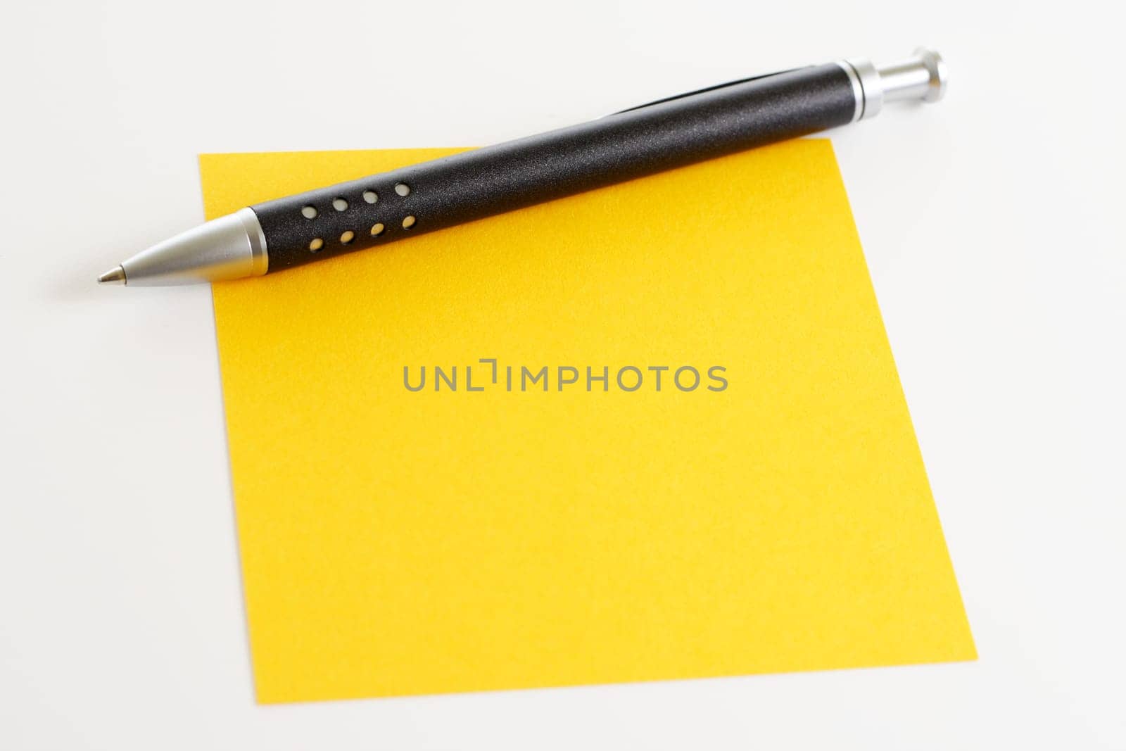 Yellow sticky note with ballpoint pen