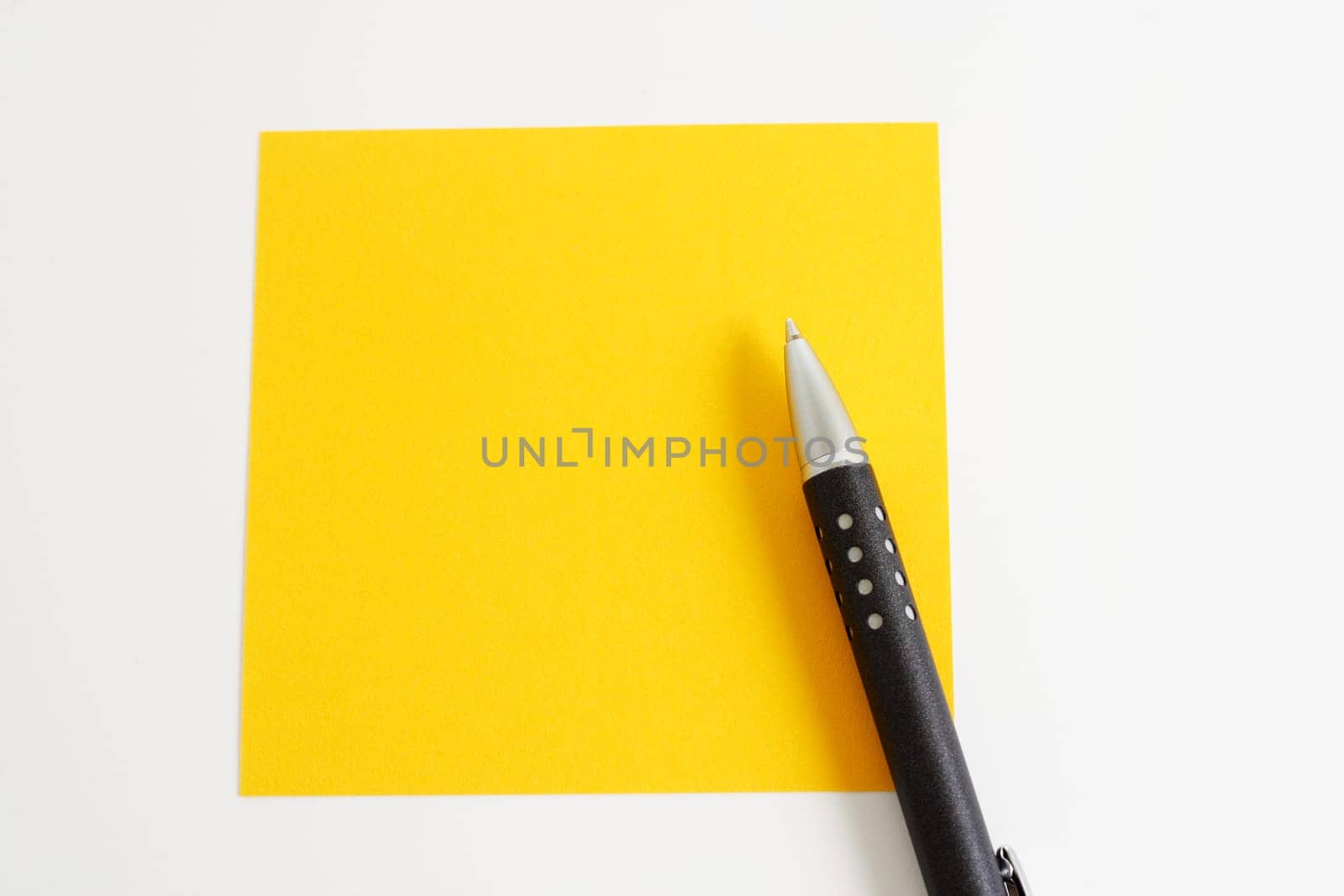 Yellow sticky note with ballpoint pen