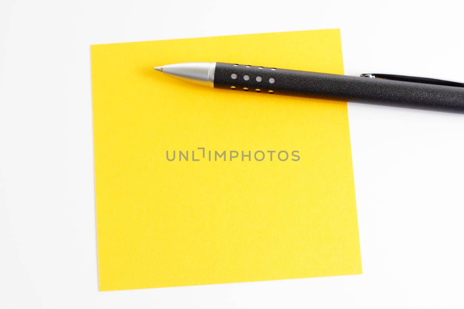Yellow sticky note with ballpoint pen