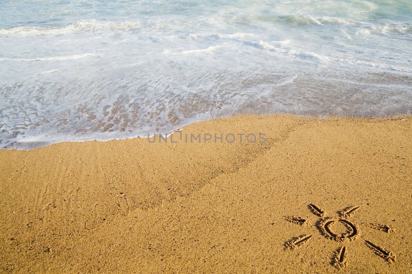 Sun painted on sand on beach