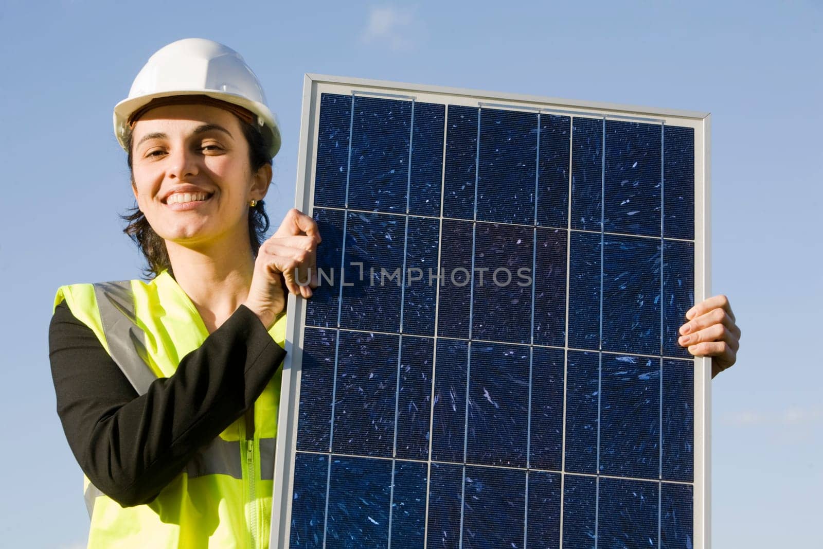Woman holding a solar panel in front of a blah