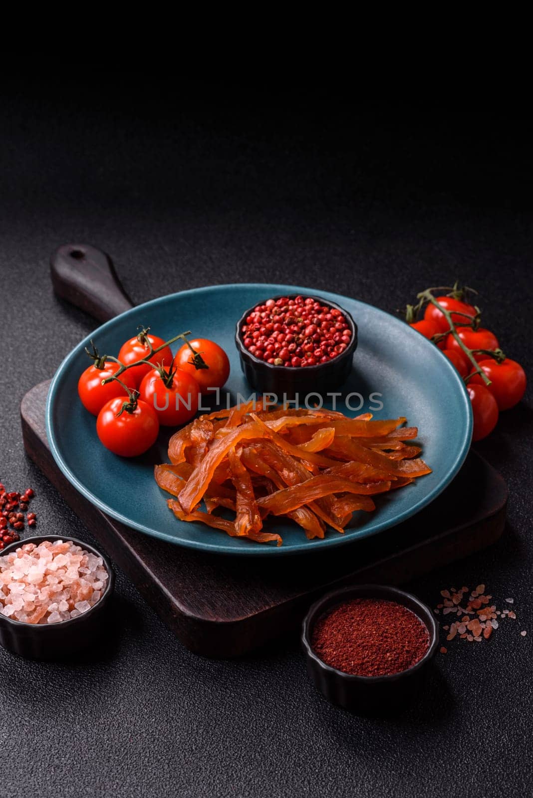 Jerky, dried turkey meat with salt and spices on a dark concrete background