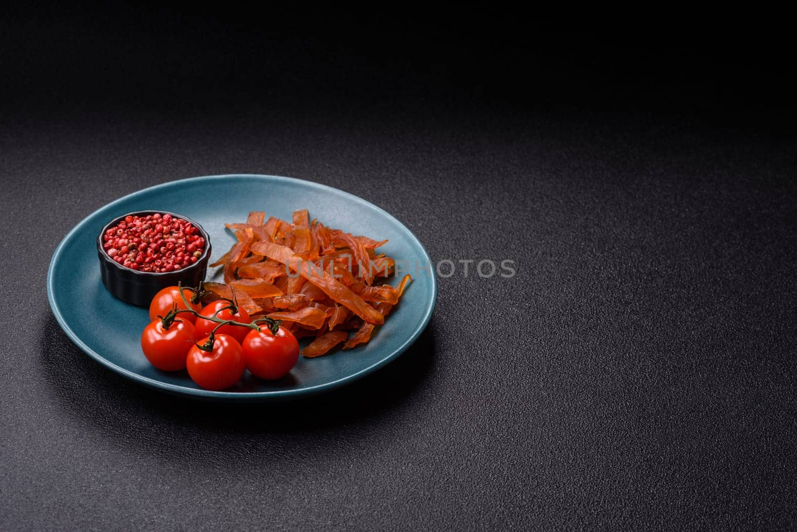 Jerky, dried turkey meat with salt and spices on a dark concrete background