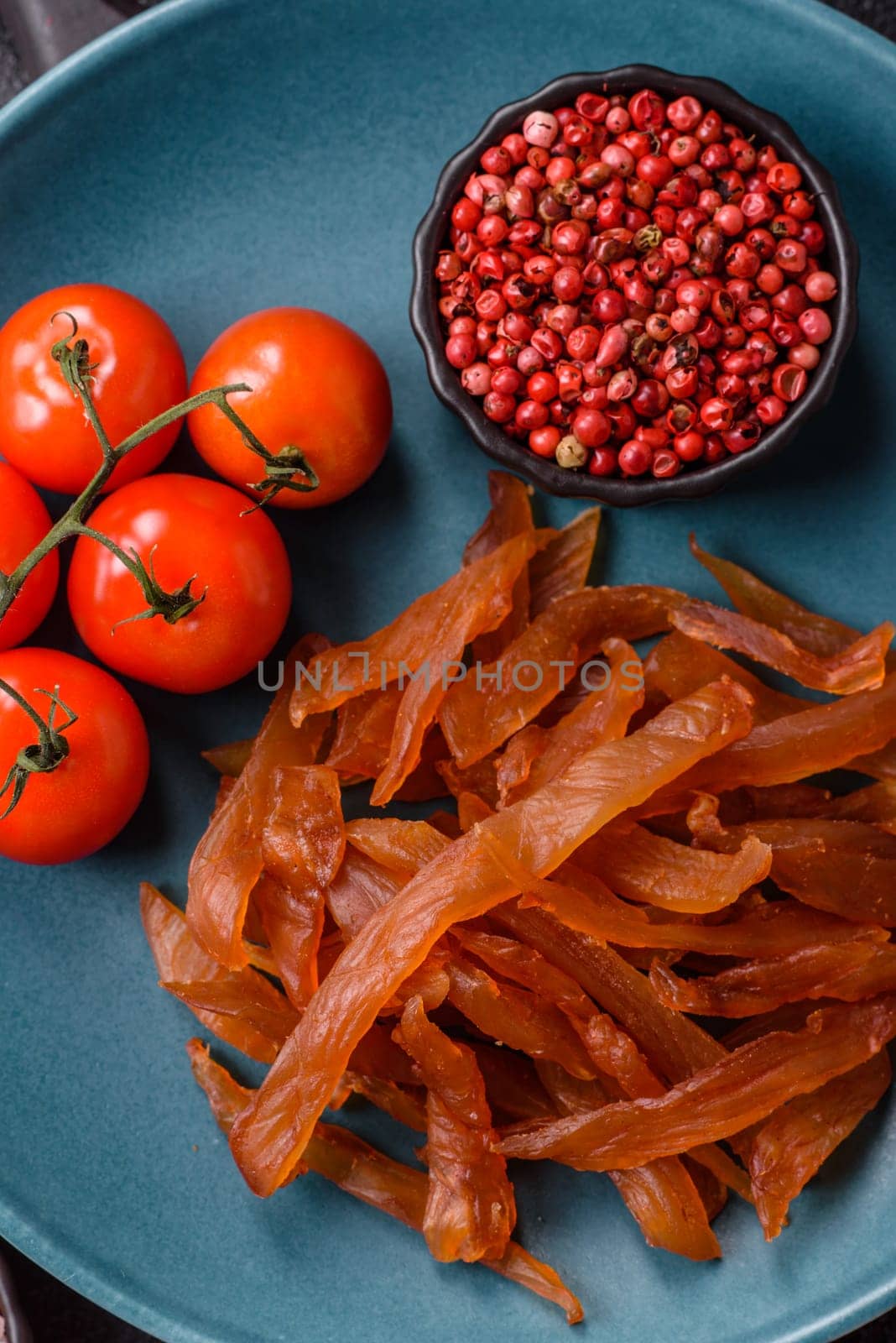 Jerky, dried turkey meat with salt and spices on a dark concrete background