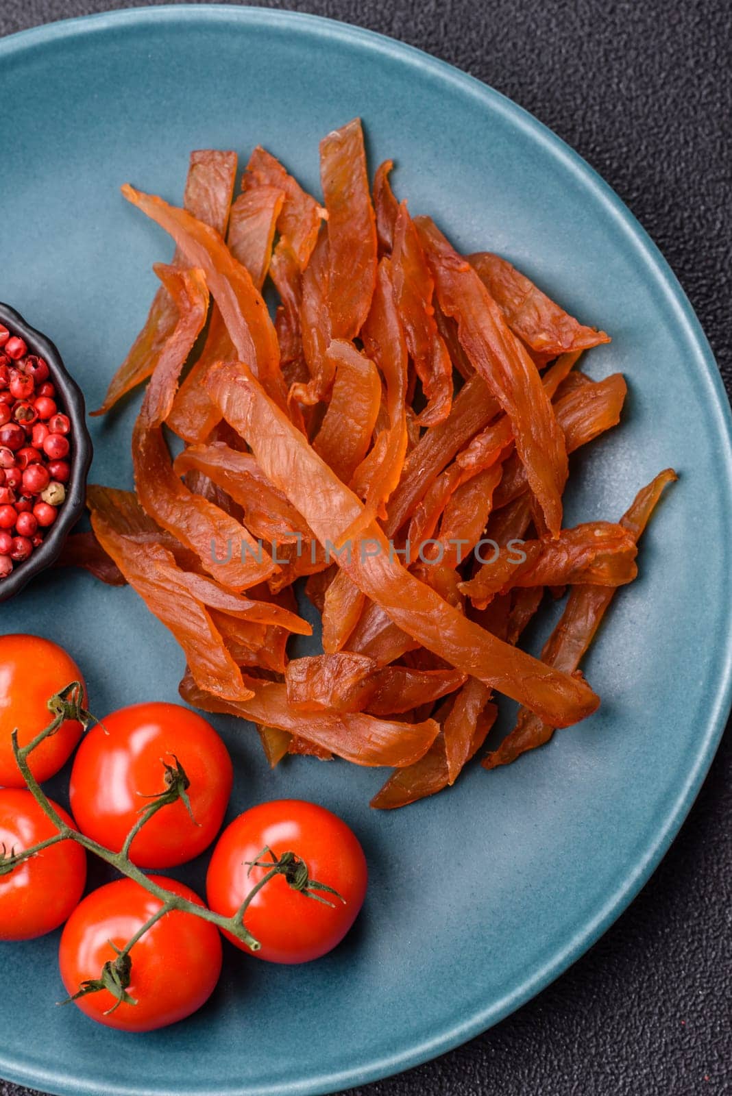Jerky, dried turkey meat with salt and spices on a dark concrete background
