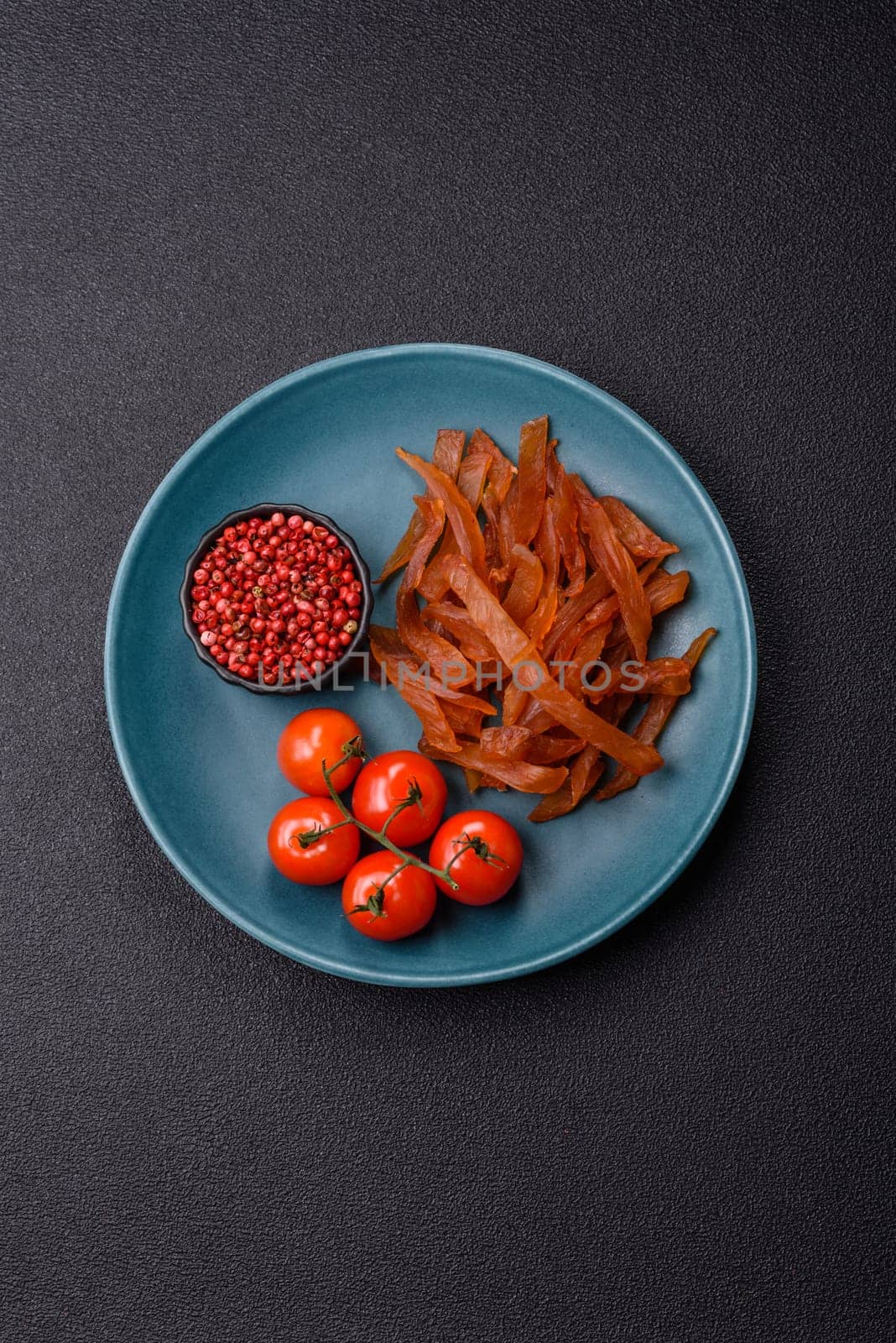 Jerky, dried turkey meat with salt and spices on a dark concrete background