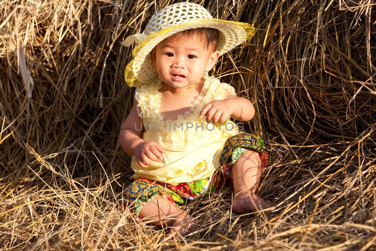 Baby girl from Asia in hay