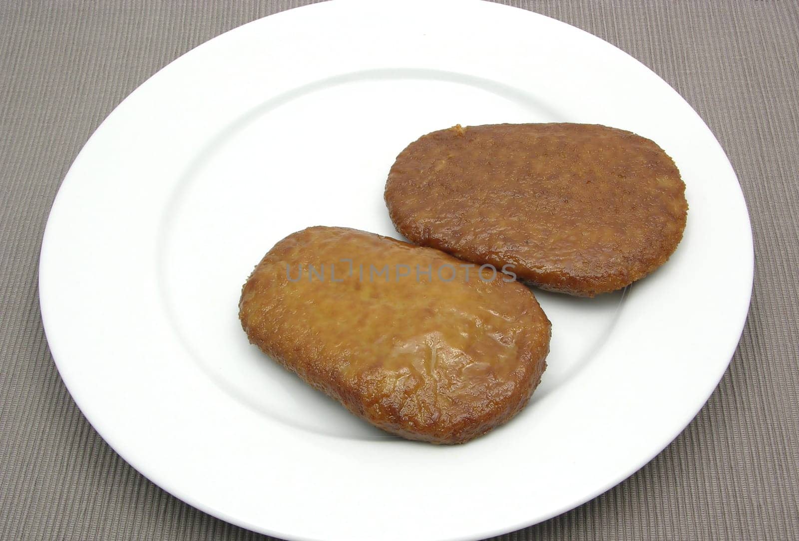 Two breaded tofu cutlets on white plate