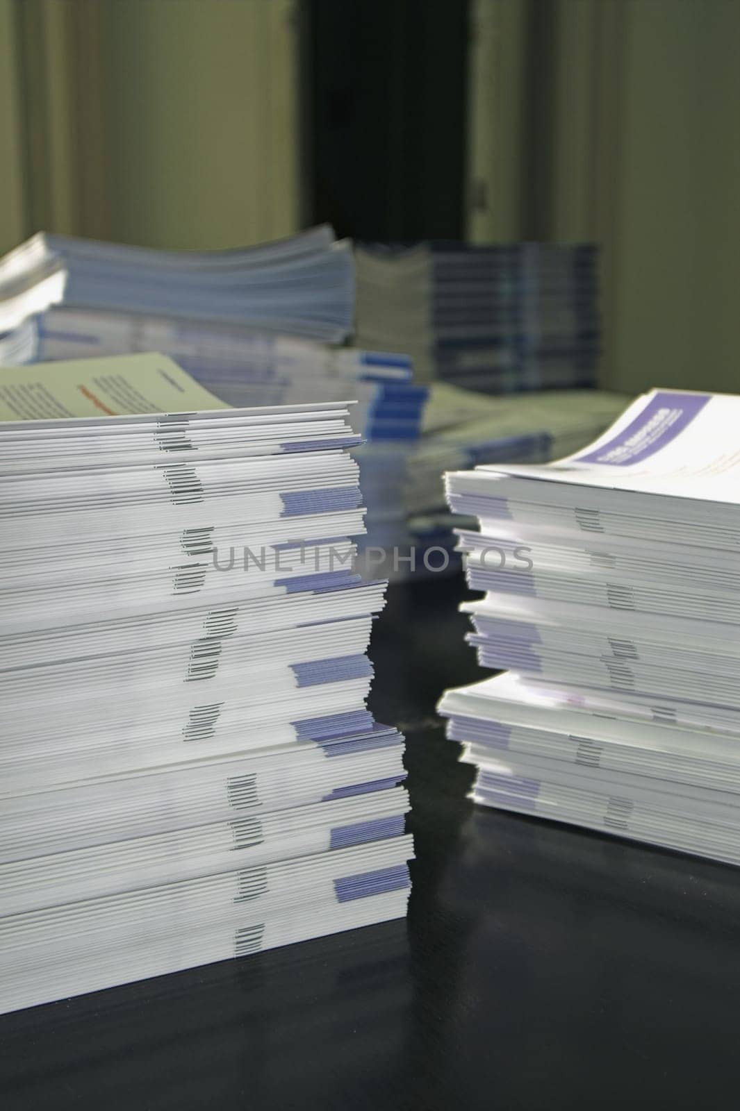 Piles of handout papers lying on a table.
